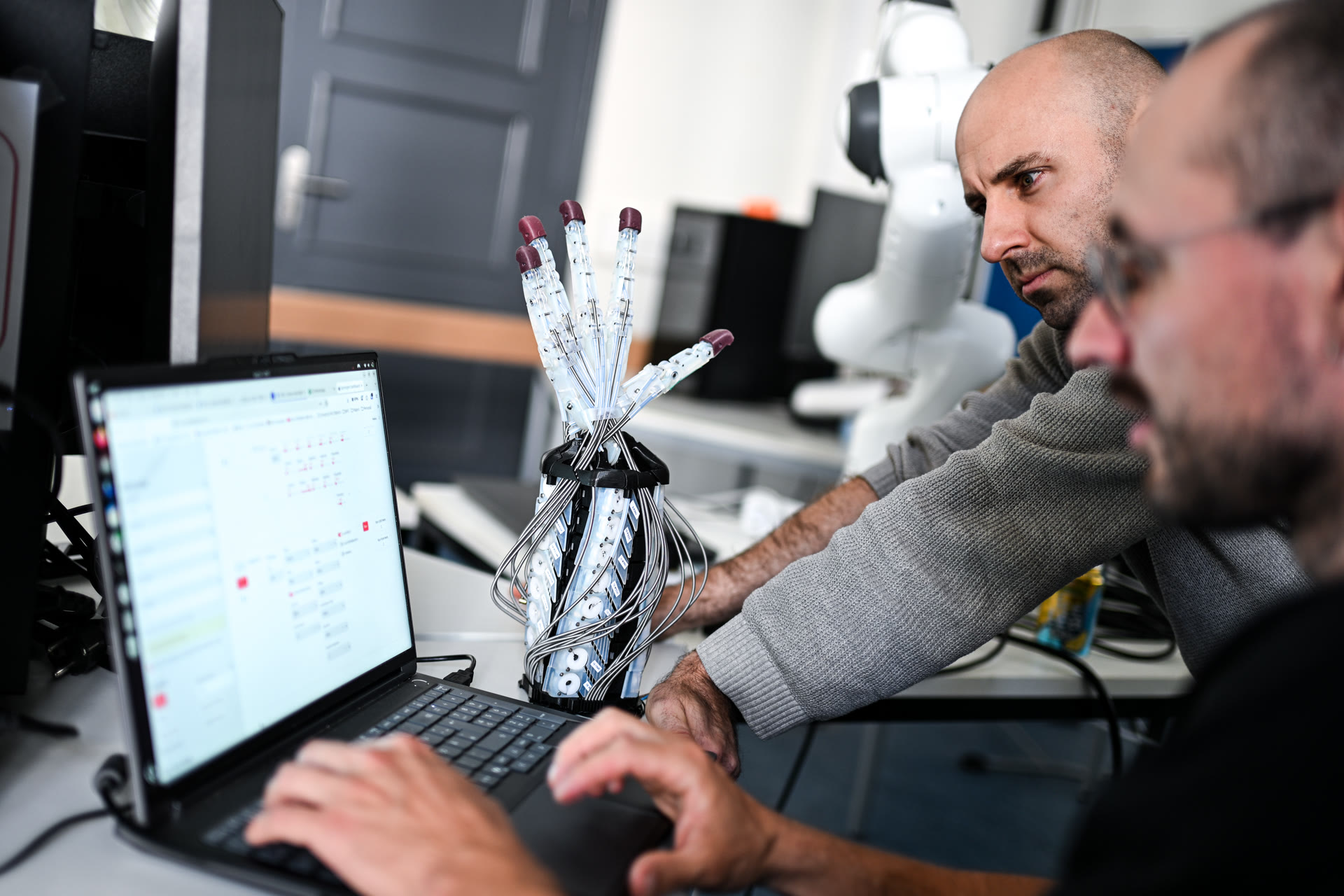 The CAPANDJI team working on the robotic hand in the lab